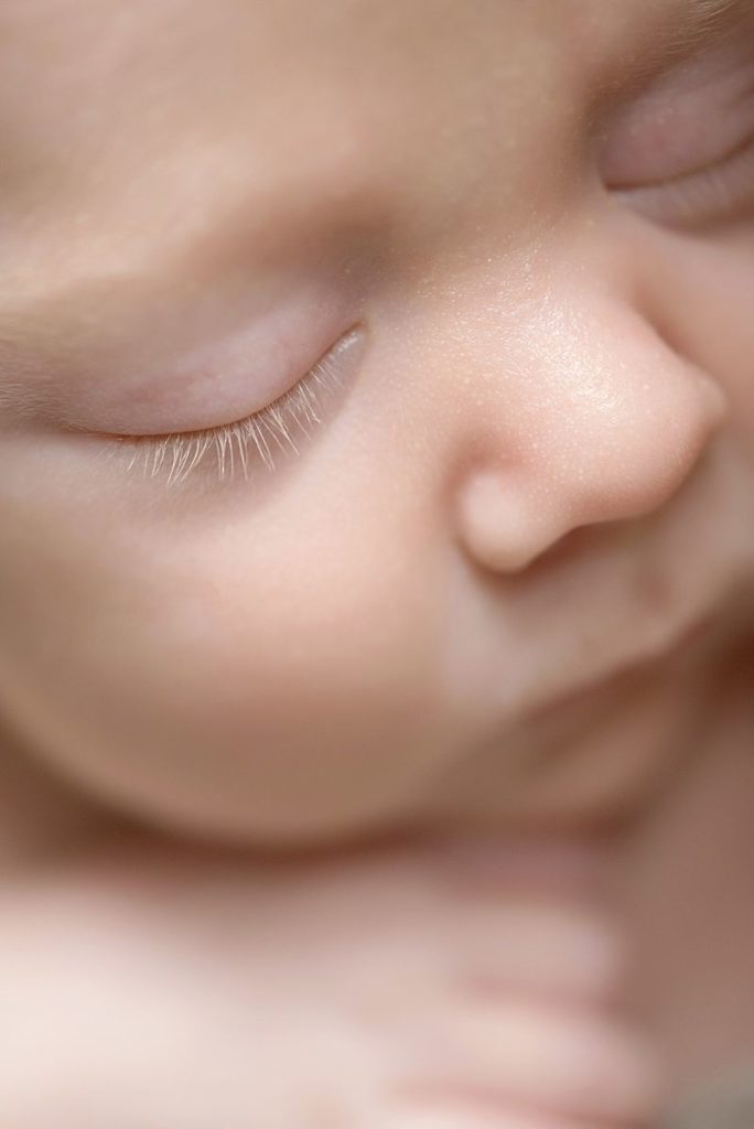 Sleeping Baby Close-Up Close-up of a sleeping baby's face showing closed eyes, eyelashes, nose, cheek, and hand.