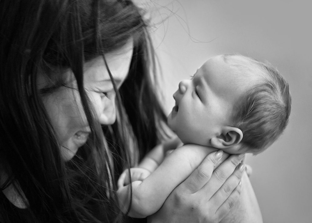 Newborn-Photography-Basingstoke-Winchester_0092 Mother laughing with newborn baby son during a natural light photoshoot in Basingstoke studio