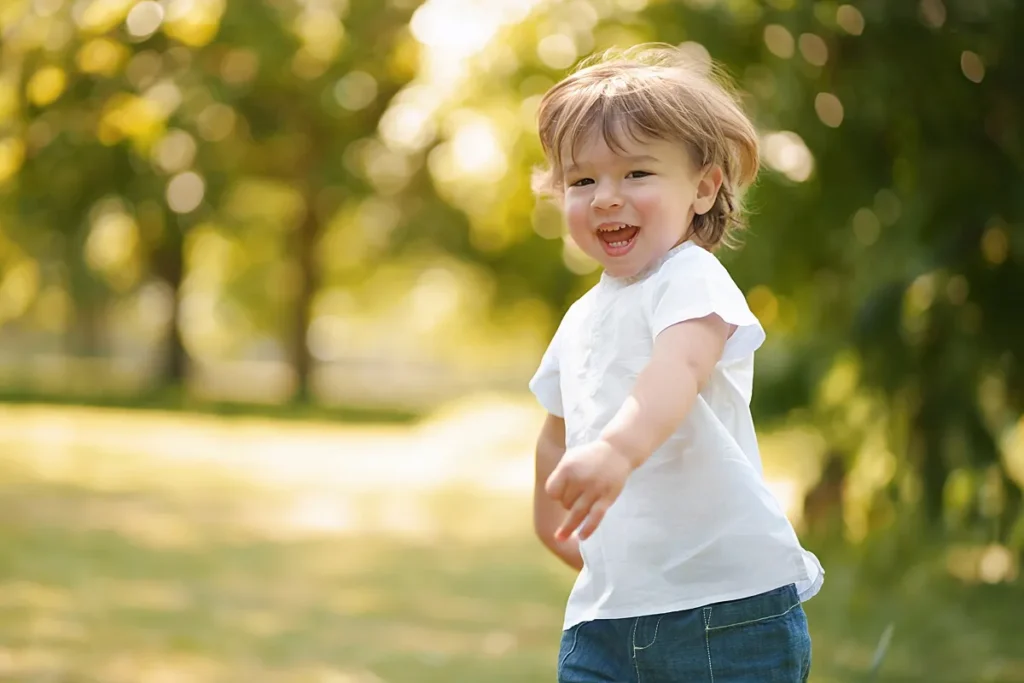 portrait of a happy toddler running in the park on a sunny day captured by family photographer Maria Cristina Licata