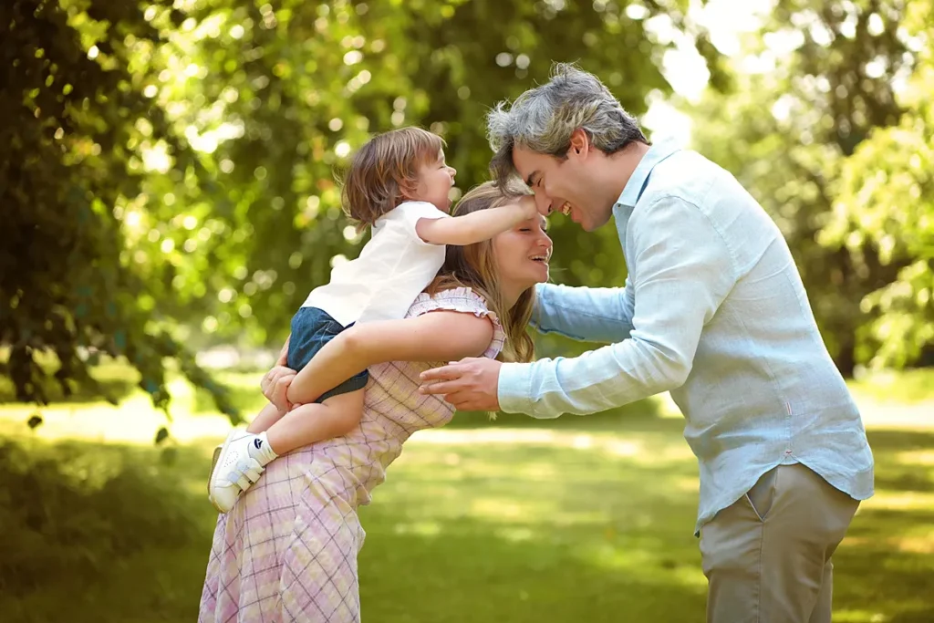 family with toddler playing in Hyde Park during an outdoor photoshoot.