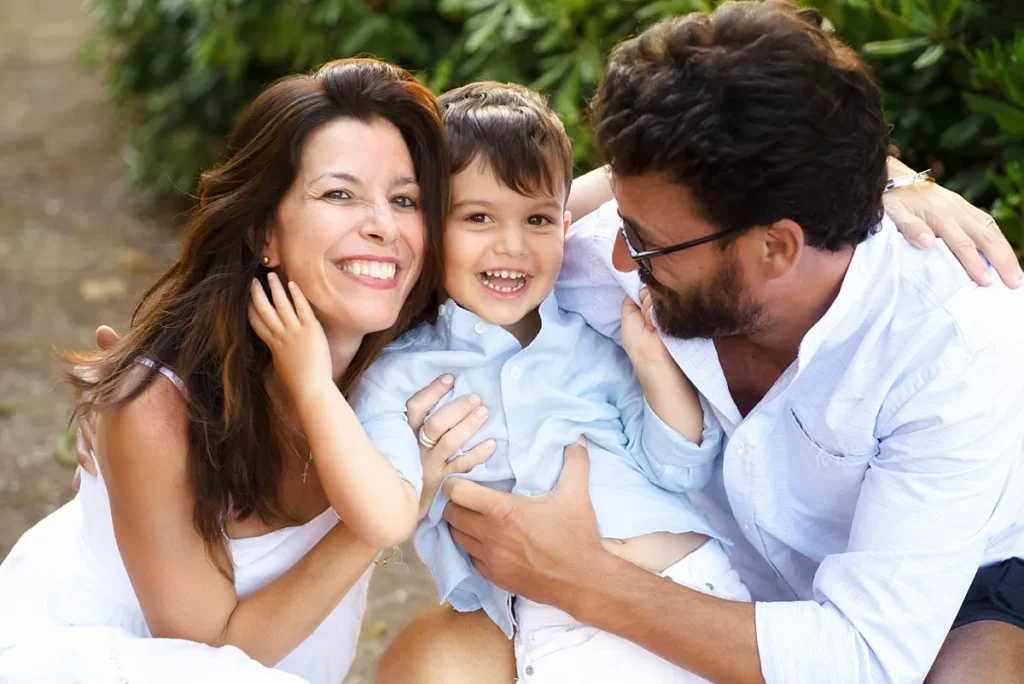 Natural outdoor family of a young family hugging and laughing. Captured in Sicily by outdoor family photographer Maria Cristina Licata