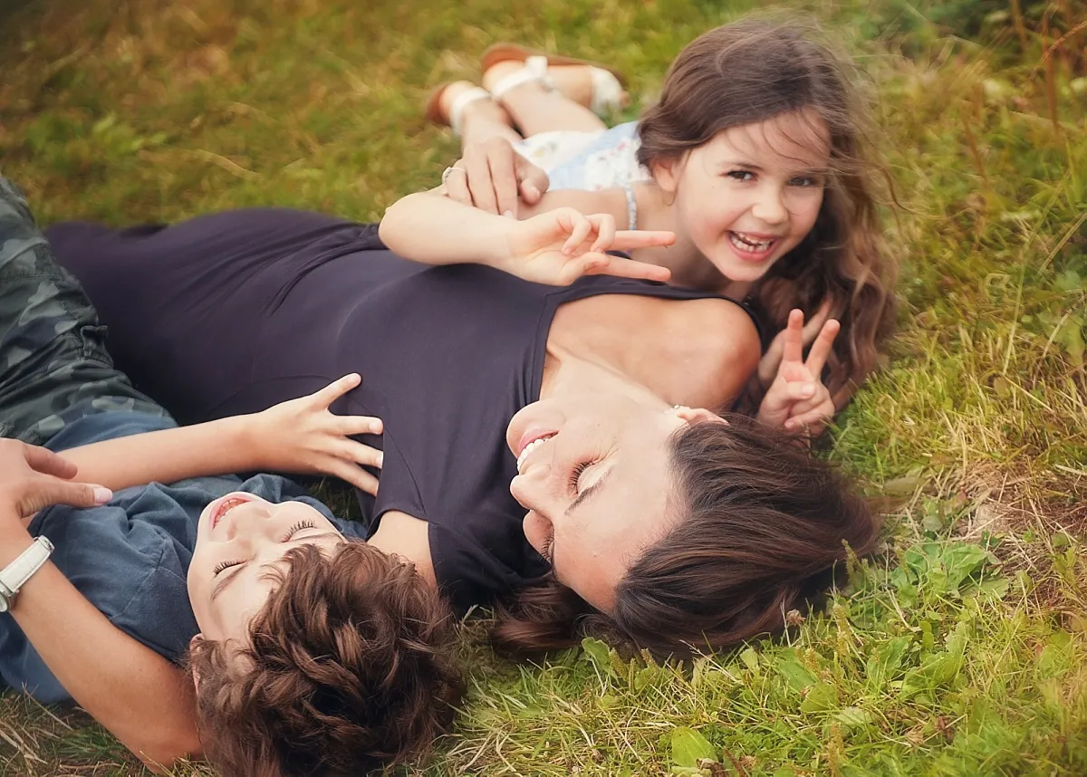 mum with son and daughter, laying on the grass cuddling. Family portrait photography near Basingstoke