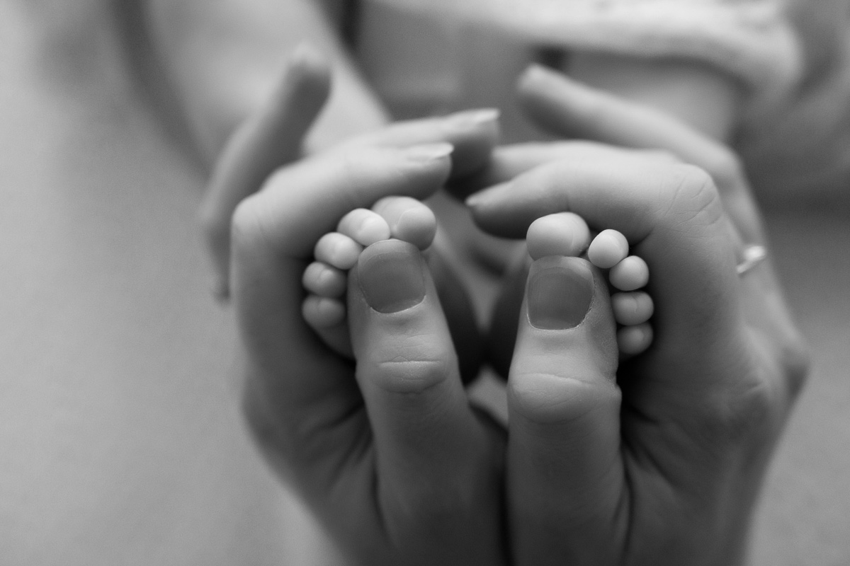 mother-baby-newborn-photoshoot-basingstoke-17 detail shot of newborn baby's feet in mum's hands during newborn photoshooot in Basingstoke Hampshire