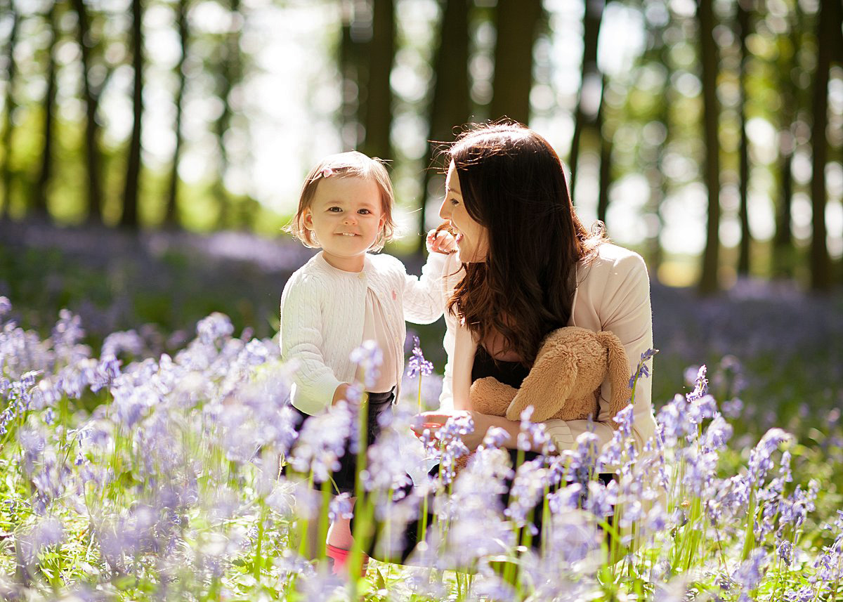 Golden hour portrait of Mum and toddler daughter in a bluebells wood during a spring family photo session