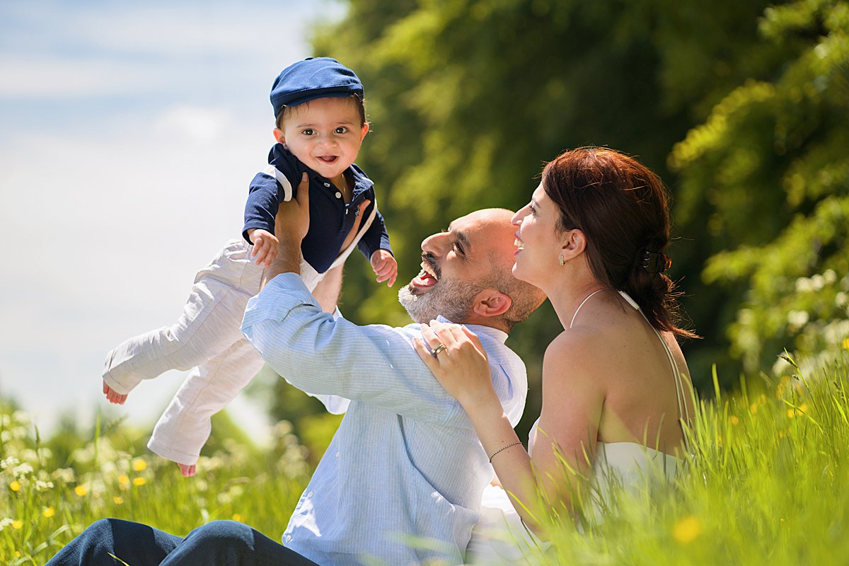A sunny portrait of a little girl sitting on a chair on the edge of a rape field during a Spring family photoshoot