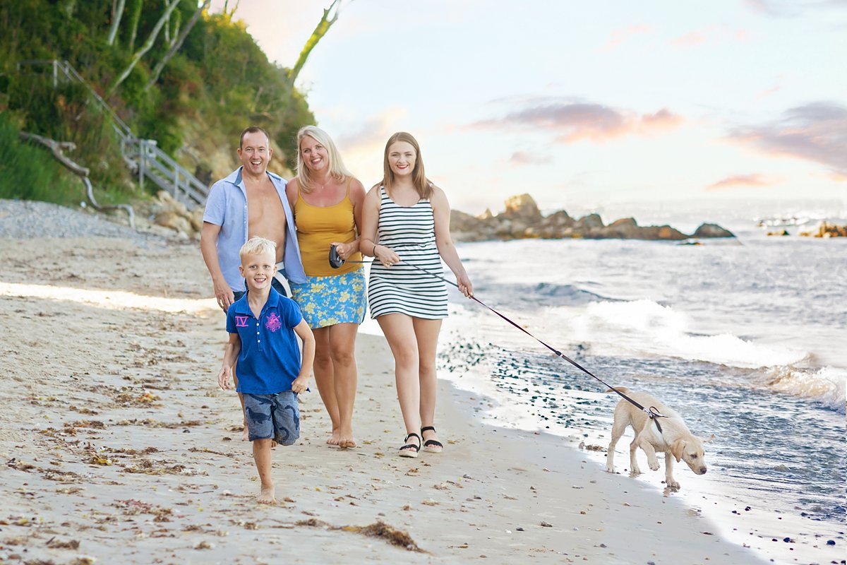 summer-family-photoshoot_0096 Multi-generational family enjoying a sunset beach walk with their dog, capturing authentic connections during seaside family photography on the Isle of Wight by Maria Cristina Licata.