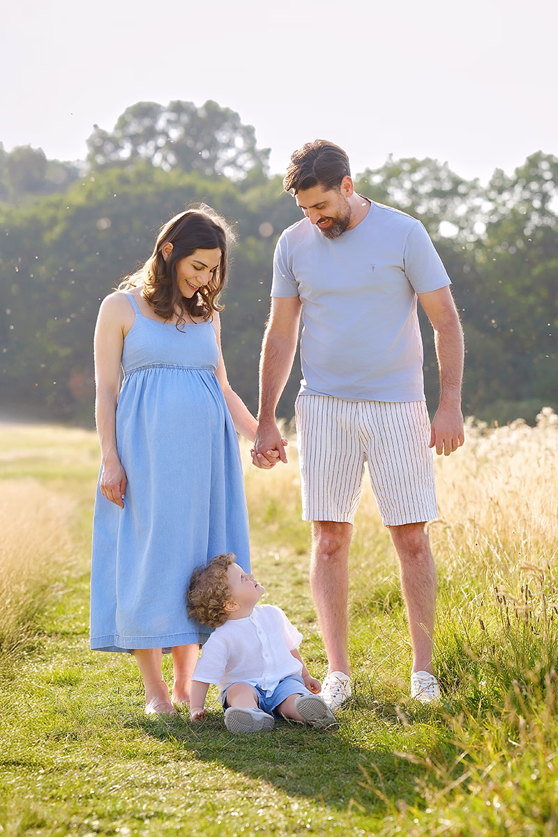 maternity-photography-sibling maternity portrait of a family with pregnant mum, dad and toddler in an outdoor setting. Natural portrait captured by pregnancy photographer Maria Cristina Licata