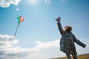 child portrait with kite and blue sky