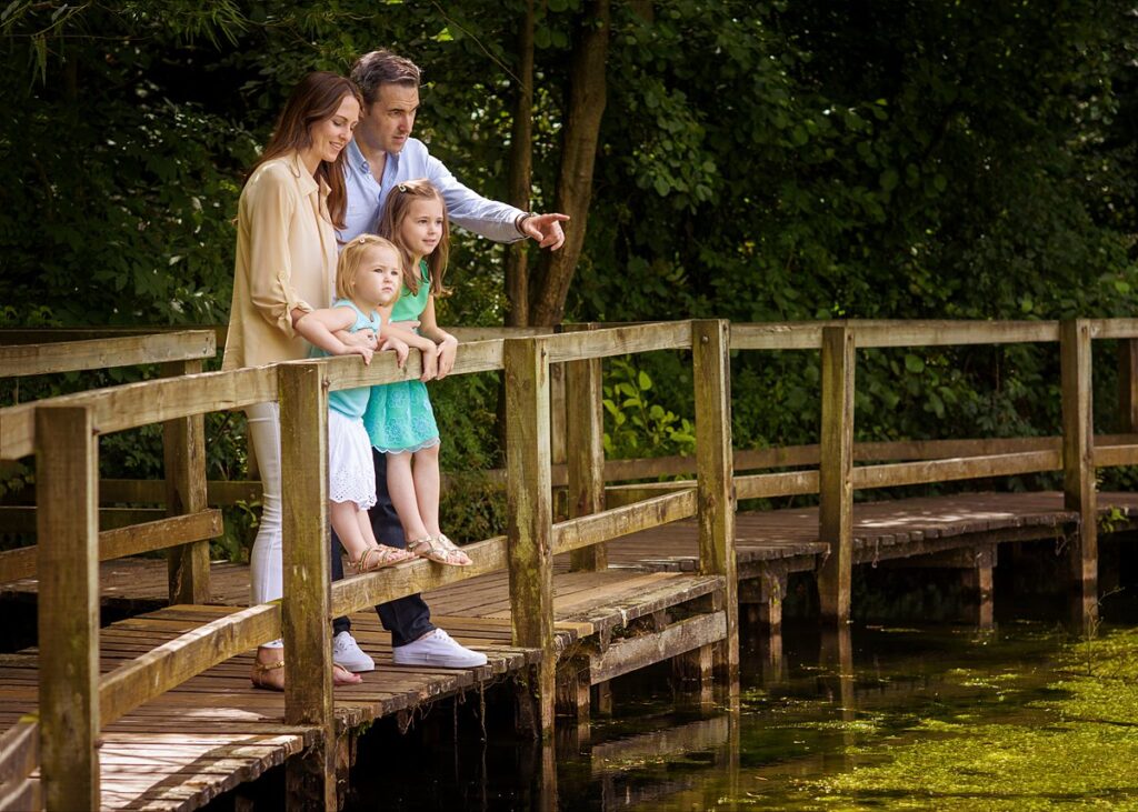 Portrait of a family on a lake jetty, taken on a natural family photoshoot at Dinton Pastures, Reading